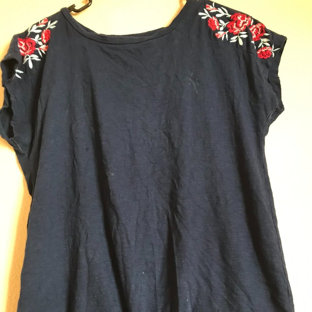 Black shirt w/ roses on the sleeves.